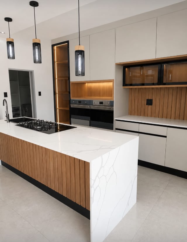 Modern custom kitchen with white marble island and wood accents